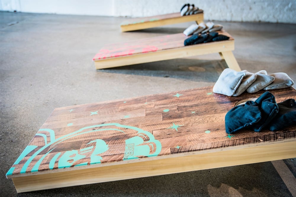 Two custom wooden cornhole boards with beanbags resting on them